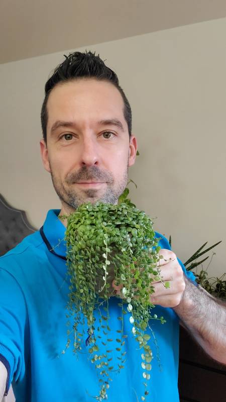 Mr. Houseplant in the blue t-shirt holding his plant